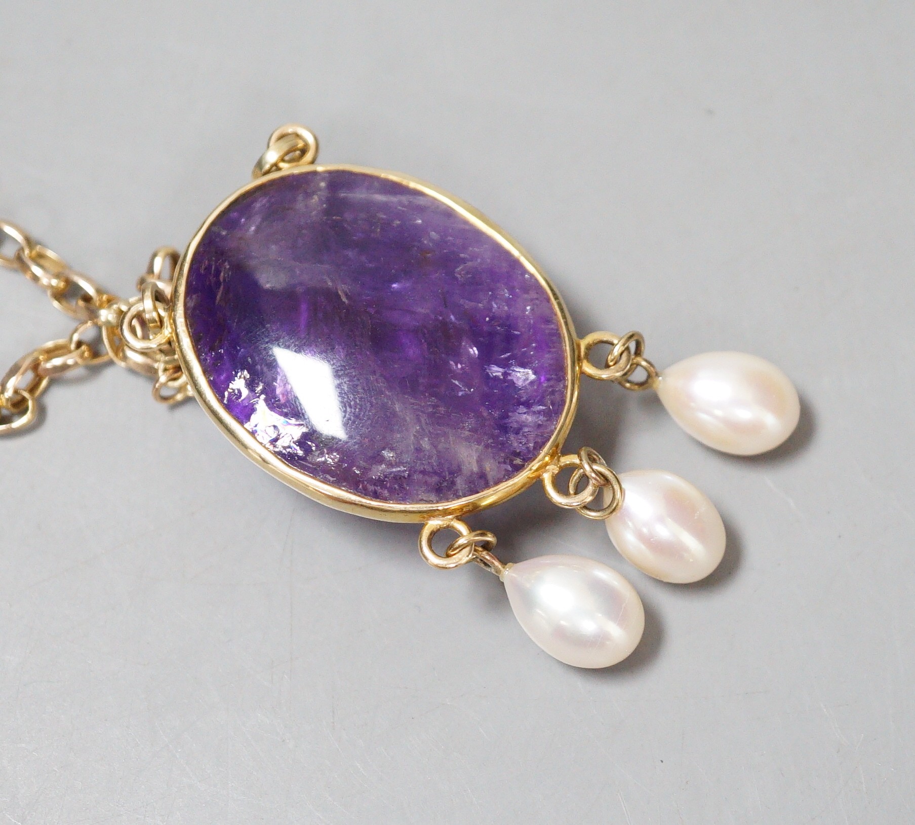 A modern 375 yellow metal mounted cabochon amethyst and three stone culture pearl set drop pendant, 58mm, on a 375 chain, 46cm, gross weight 37.8 grams.